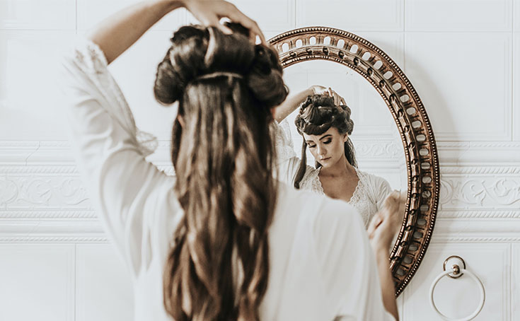 Mujer maquillándose frente a un espejo